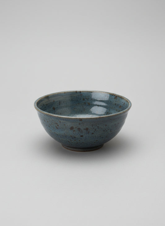 Ceramic bowl with speckled texture on a white service