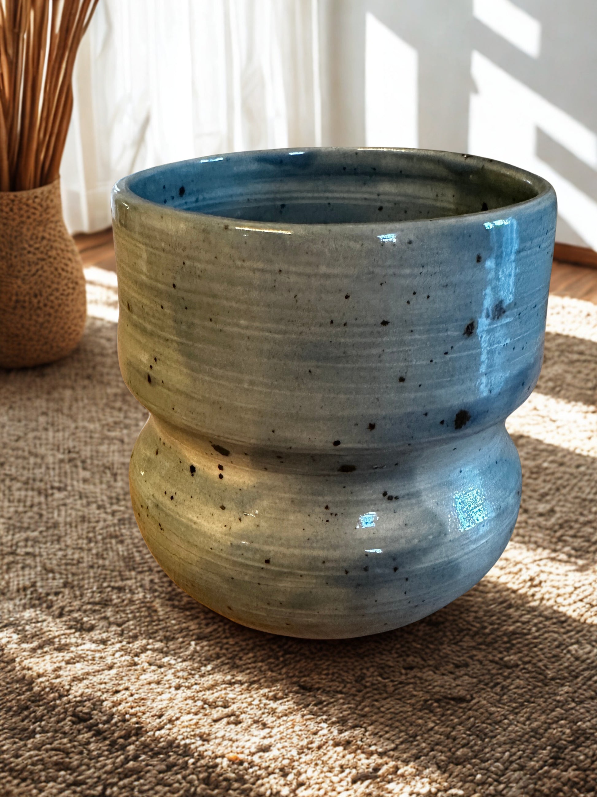 Blue ceramic vase on a textured surface.