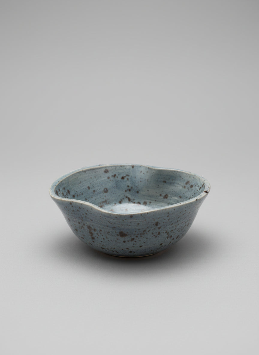 Speckled ceramic bowl on a white  surface