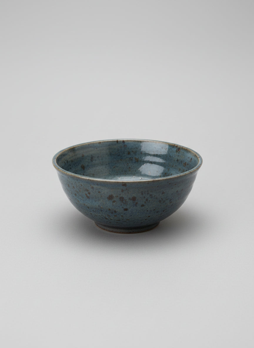 Ceramic bowl with speckled texture on a white service